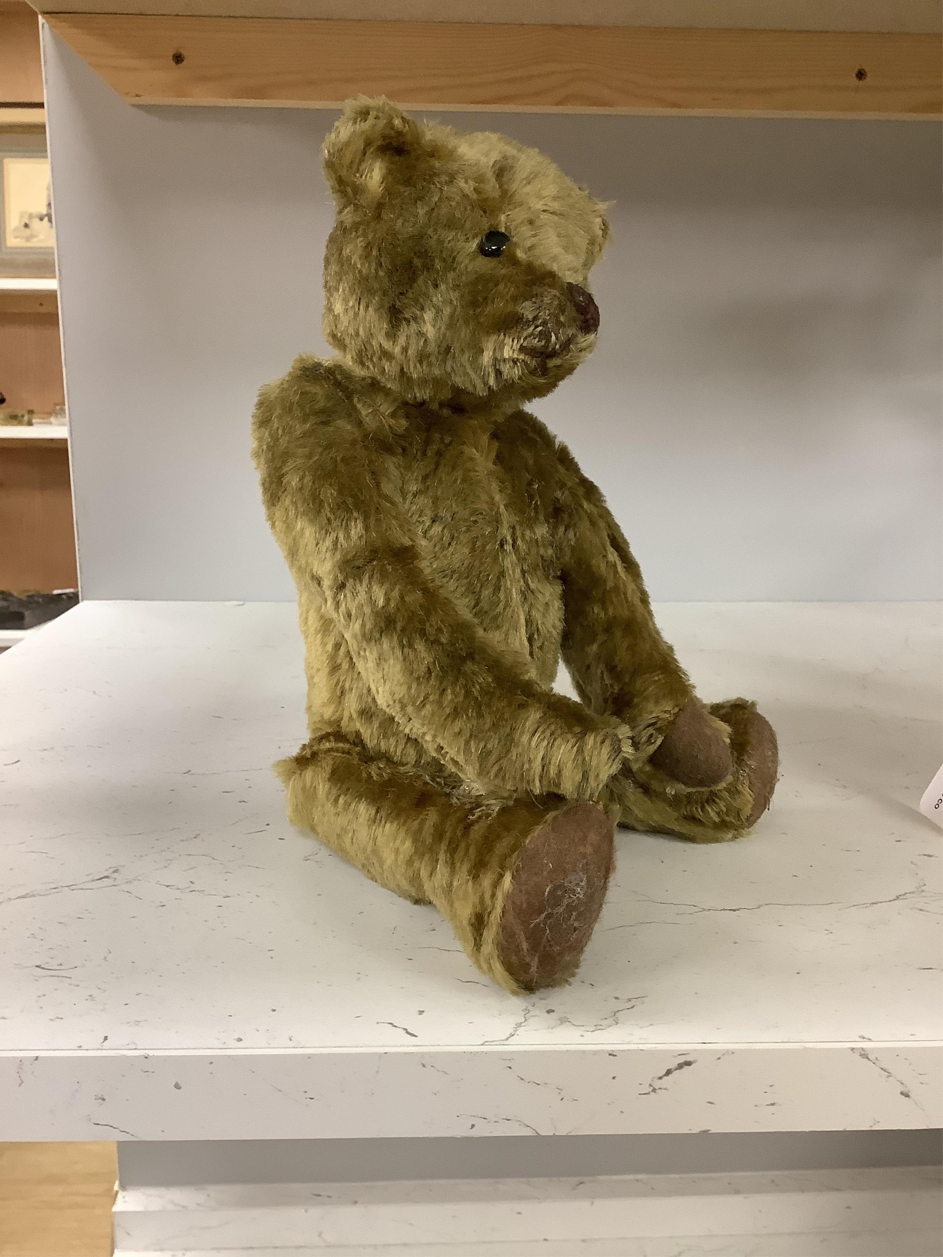 An early 20th century German hump backed plush teddy bear and three others, German teddy 30cm high. Condition - the German teddy has a short split on the back seam and glue on the front leg that needs removing and plush